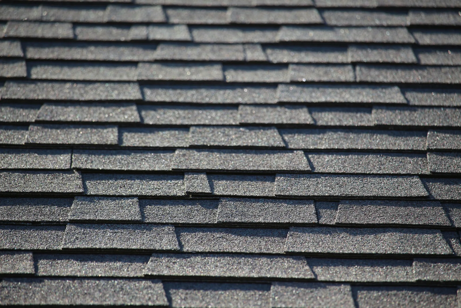 Sunlit granulated asphalt shingle courses with overlapping tabs